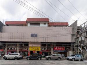 巴科洛德Check Inn Bacolod by RedDoorz的前面有汽车停放的建筑