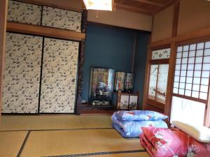 InashikiINASHIKI NEST的客厅拥有蓝色的墙壁和窗户,配有沙发
