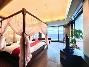 别府SKY Tower Sweet 4 Beppu, Resort Love Hotel的一间卧室设有一张天蓬床,享有海景