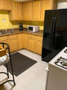 辛辛那提Cozy home 5 beds private yard的厨房配有木制橱柜和黑色冰箱。