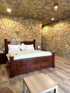 阿尔哈姆拉jabal shams view stay نزل إطلالة جبل شمس的石墙房间内的一张床位