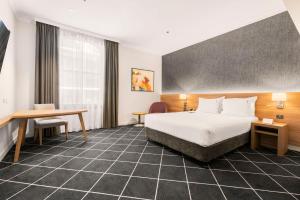 悉尼Furama Darling Harbour的配有一张床和一张书桌的酒店客房