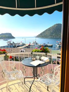 博德鲁姆Liman Hotel Gümüslük - Adult Only的海滩景阳台配有桌椅