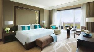 阿布扎比Anantara Eastern Mangroves Abu Dhabi的酒店客房设有一张大床和一张书桌。