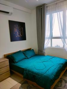 瓜拉丁加奴Sofia Homes Kuala Terengganu的一间卧室设有蓝色的床和窗户。