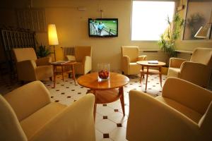 贝尔维尔德赛当亚贝拉维斯塔酒店的一间设有椅子和桌子的等候室以及一台电视