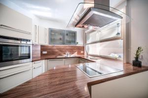 阿皮亚诺苏拉斯特拉达Ferienhaus - Das Goldgassl的厨房配有白色橱柜和木制台面