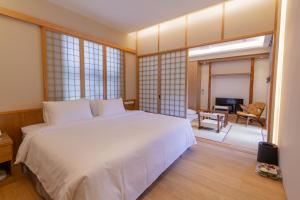 九份金漫會館-金瓜石九份景觀民宿-Jien Mount Villas的一间带白色床的卧室和一间客厅