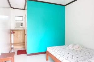 ItaytayLMIRAMARS Tourist Inn的一间卧室设有绿色的墙壁和一张床