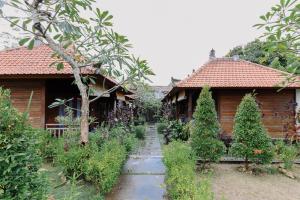蓝梦岛The Lavana Jhonny Kibung Villas Lembongan的两栋木屋前的花园
