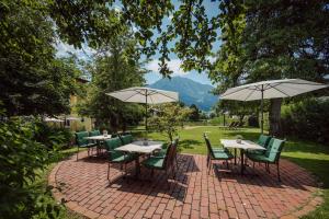 蓬高圣约翰勒赫伯朗肯乡村酒店的一个带桌椅和遮阳伞的庭院。