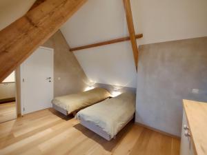 克勒伊斯贝尔亨Nachtegael Hoekhuis, knusse woning met prachtig vergezicht的阁楼间设有两张床,铺有木地板