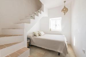 贝赫尔-德拉弗龙特拉Casa Manuela的白色卧室设有床和楼梯