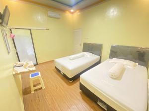 MatakaliHomestay RN near Taman Bambu Runcing Polewali Mitra RedDoorz的小房间设有两张床和体重秤