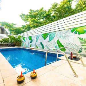 巴加Infinity Villa, 5BHK-Private Pool-Caretaker, Baga的一座建筑的一侧,设有一座带壁画的游泳池