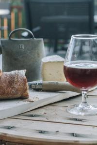 圣让德莫里耶讷CHALET HOTEL La TUVIERE BIKE INN的坐在桌子上,一边品尝葡萄酒,一边品尝奶酪和面包