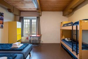 西姆斯科克Stayokay Hostel Heemskerk的客房设有两张双层床和一张桌子。