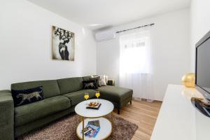 希贝尼克Apartman Ivana的客厅配有绿色沙发和电视