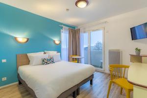凯恩Appart'City Classic Caen的一间卧室设有一张蓝色墙壁的大床
