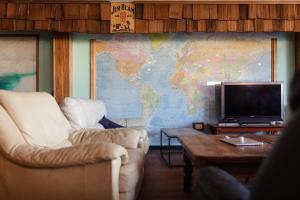 悉尼过境背包客经济汽车旅馆的客厅配有两把椅子、一台电视和一张地图