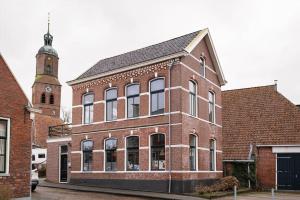 EenrumSfeervol verblijf in oude gemeentehuis Eenrum.的一座带钟楼的大型砖砌建筑