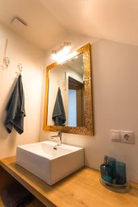 姆尔斯拉格斯Brīvdienu māja Saule的浴室设有白色水槽和镜子