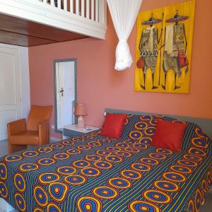 索蒙Havre De Paix的一间卧室配有一张大床和色彩缤纷的毯子