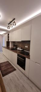 普雷代亚尔Alexys Top Residence Predeal的厨房配有白色橱柜和炉灶烤箱。