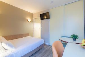 南特Appart'City Confort Nantes Cité des Congrès的酒店客房配有一张床铺和一张桌子。