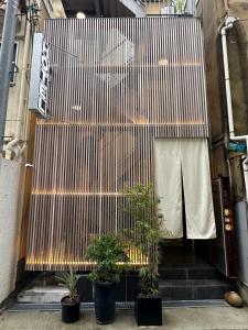 大阪Hotel 草石庵的建筑前有盆栽植物的楼梯