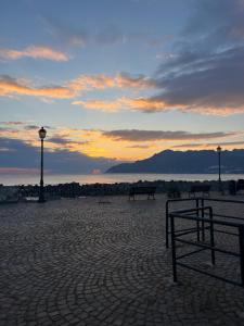 萨莱诺Borgo Marinaro Suite的海滩上的长凳,背景是日落