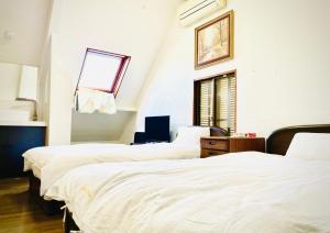 东京新宿直通完全貸切一軒家的一间卧室设有三张床和窗户。