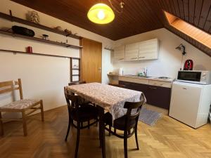 萨格勒布Cozzy apartment in nature的厨房配有桌椅和冰箱。