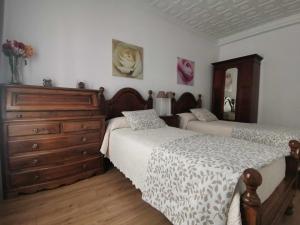 托莱多Casa Cervantes Toledo的一间带两张床和梳妆台的卧室
