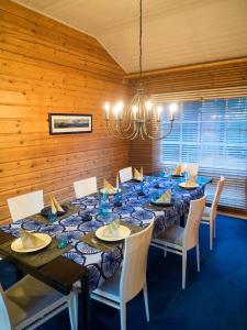 埃克奈斯Villa Mustikka的用餐室配有长桌子、椅子和吊灯