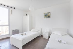 马赛NEW JOLIETTE Comfortable Apartment well located with private parking的白色的客房设有两张床和窗户。