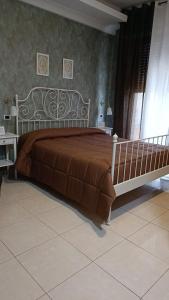 庞贝多齐维塔B&B酒店的一间卧室配有一张大床和棕色床罩