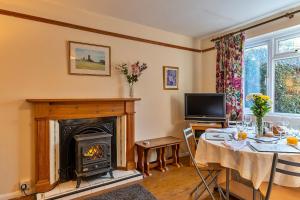 惠灵顿Finest Retreats - Glebe Cottage的客厅配有桌子和壁炉