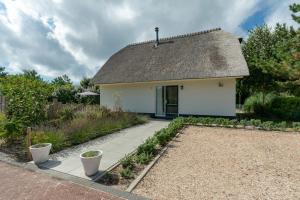朱丽安娜多普Villa Duynopgangh 16 Julianadorp aan Zee的白色的小房子,带有茅草屋顶