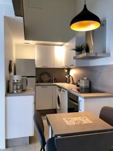 圣普列斯特T2 en duplex & terrasse的厨房配有白色橱柜和桌椅