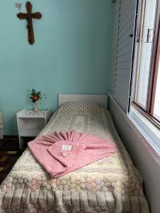 拉热斯Pousada Irmãs Franciscanas的一张床上的粉红色长袍