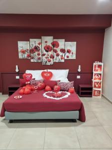 PatricaRosy's Rooms的一间卧室配有一张红色大床,上面有西红柿