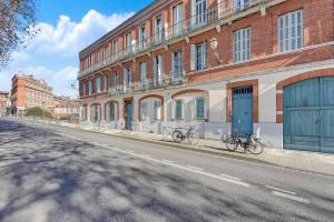 图卢兹L'île aux Tounis - T3 Moderne centre de Toulouse的停放在砖砌建筑前面的两辆自行车