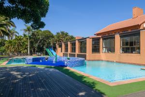 绍斯布鲁姆San Lameer Villa 11703 - 5 Bedroom Luxury - 10 pax - San Lameer Rental Agency的大楼前带滑梯的游泳池