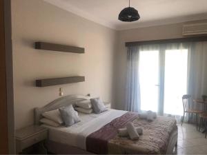 阿依亚埃夫菲亚海神公寓式酒店的一间卧室设有一张床和一个大窗户