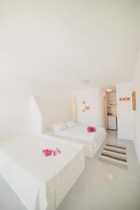 MérikhasKontseta的白色的客房配有2张白色的床和鲜花