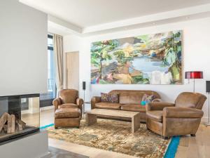 奥斯赛拜-塞林Villa Philine - Penthouse 28 mit Panoramablick, Pool, SPA & Kamin的客厅配有沙发、两把椅子和一幅画