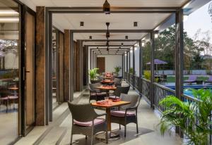 门格洛尔Vivanta Mangalore Oldport Road - Formerly Known as Taj Manjarun的阳台餐厅,配有桌椅