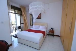 恩德培Frontiers Hotel & Conference Entebbe的卧室设有一张白色大床和一扇窗户。