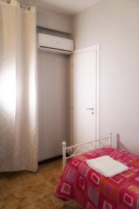 卡普阿B&B Porta Roma的一间卧室配有一张带红色毯子的床和窗户。